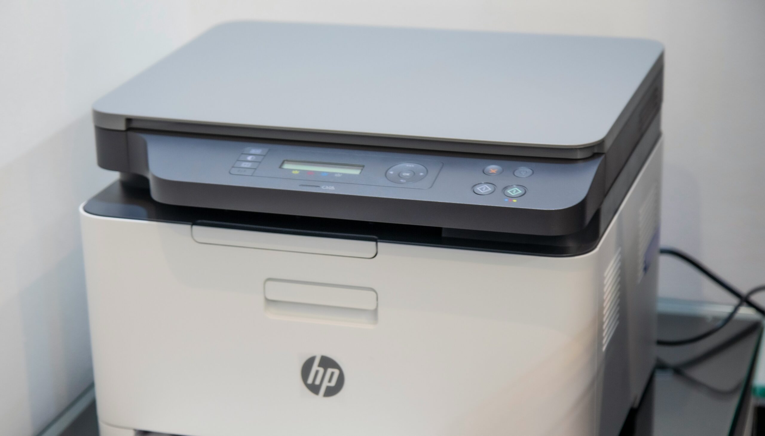 Closeup image of a grey HP printer with control panel and buttons